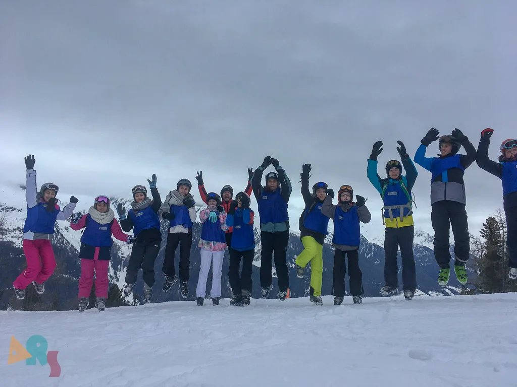 Gruppe jubelt in der Dämmerung auf der Piste.